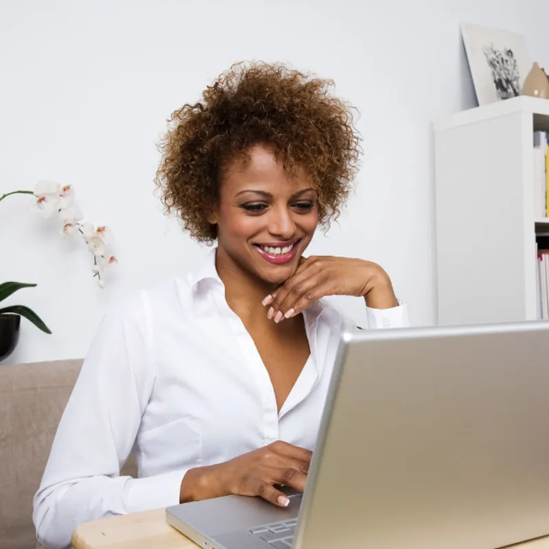 Adult student smiling at her laptop at home
